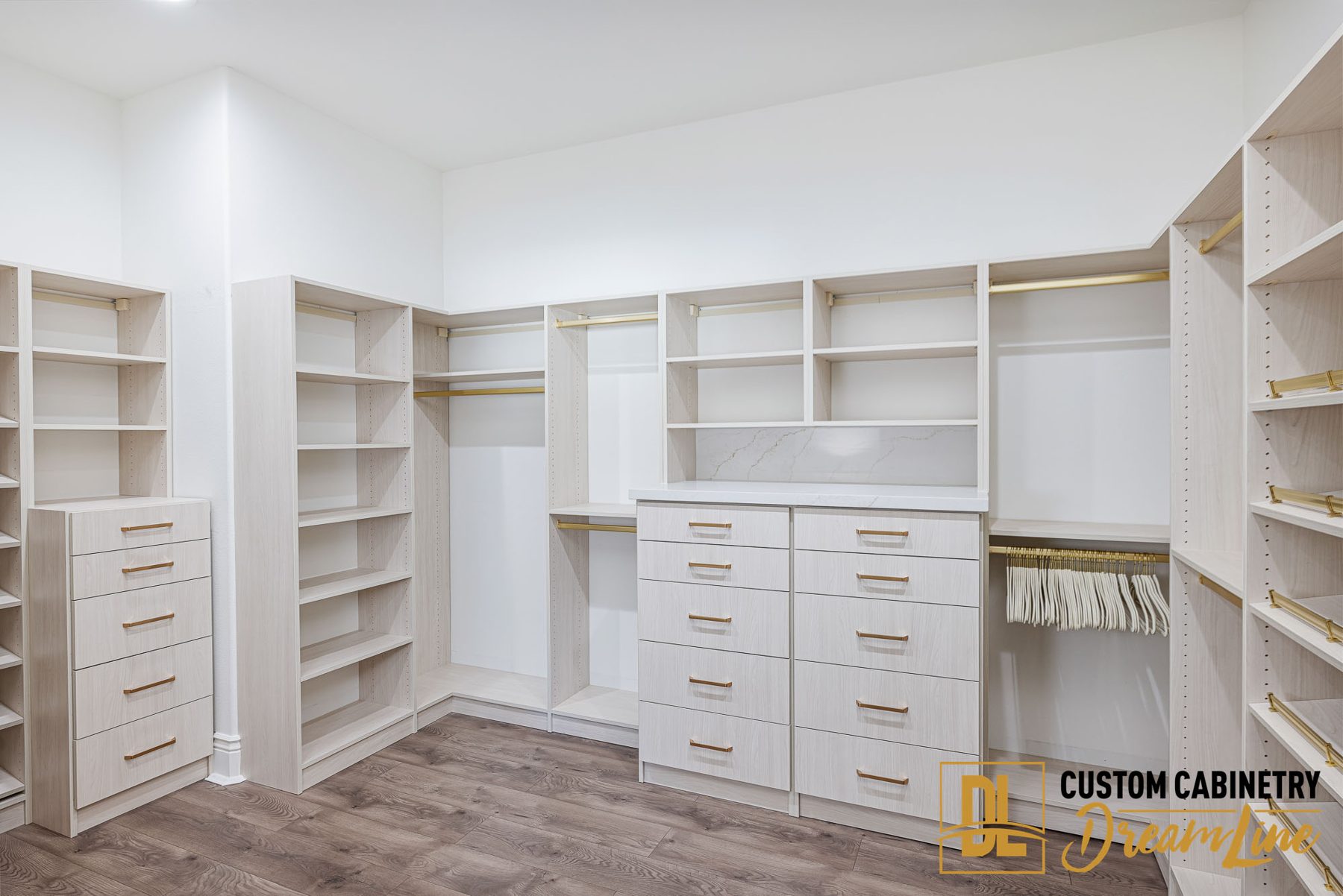 A walk-in closet with shelving and drawers